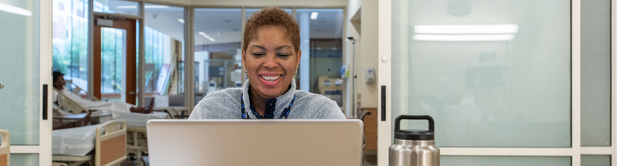 A professor speaks with students on a laptop
